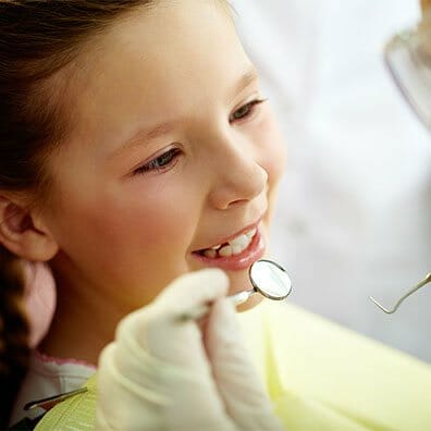 Young girl getting her teeth examined